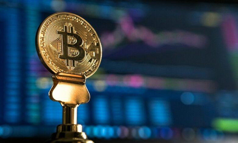 selective focus photo of Bitcoin near monitor