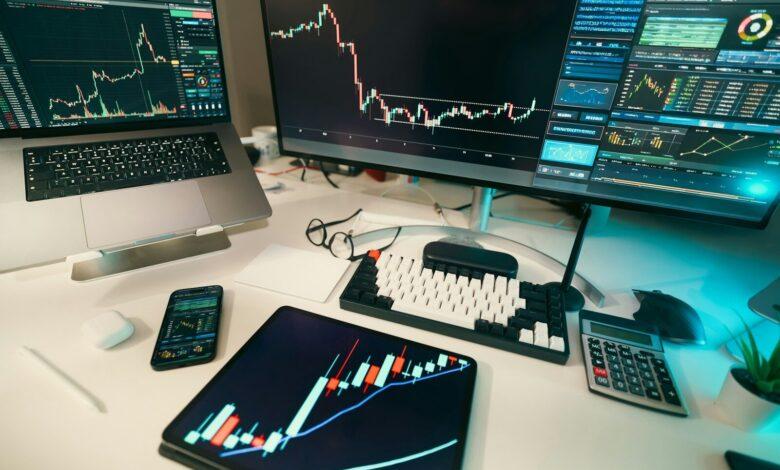 Stock charts are displayed on multiple screens.